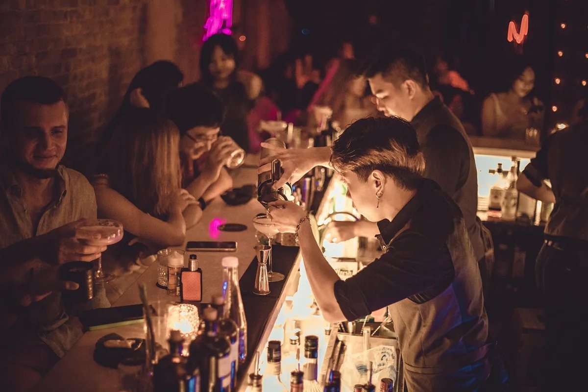 Guests and warm bar lighting at Bloom, 14 Nguyen Thiep
