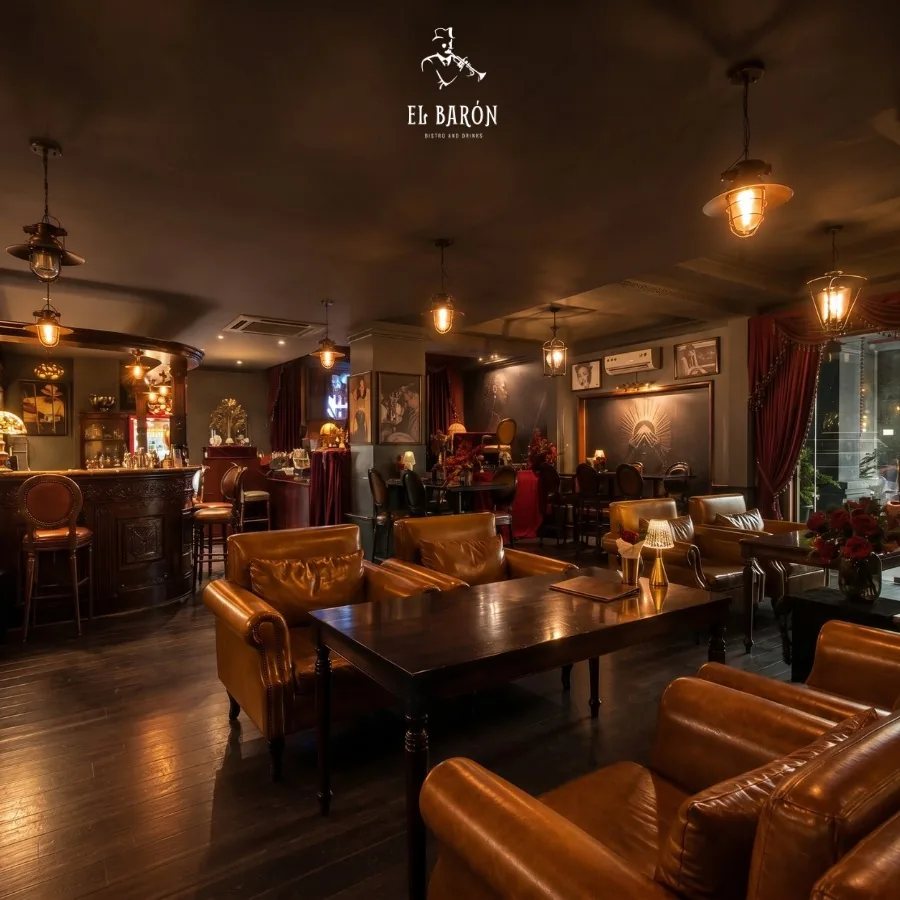 El Barón lounge at 42 Hưng Phước 4, with leather seating, warm pendant lighting and the bar