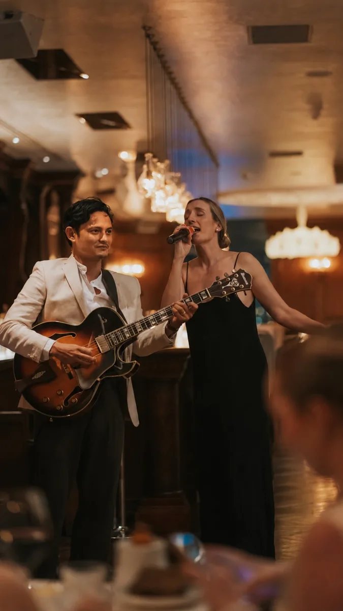 Jazz singer and guitarist performing in a restaurant setting, from The Albion Friday jazz announcement.