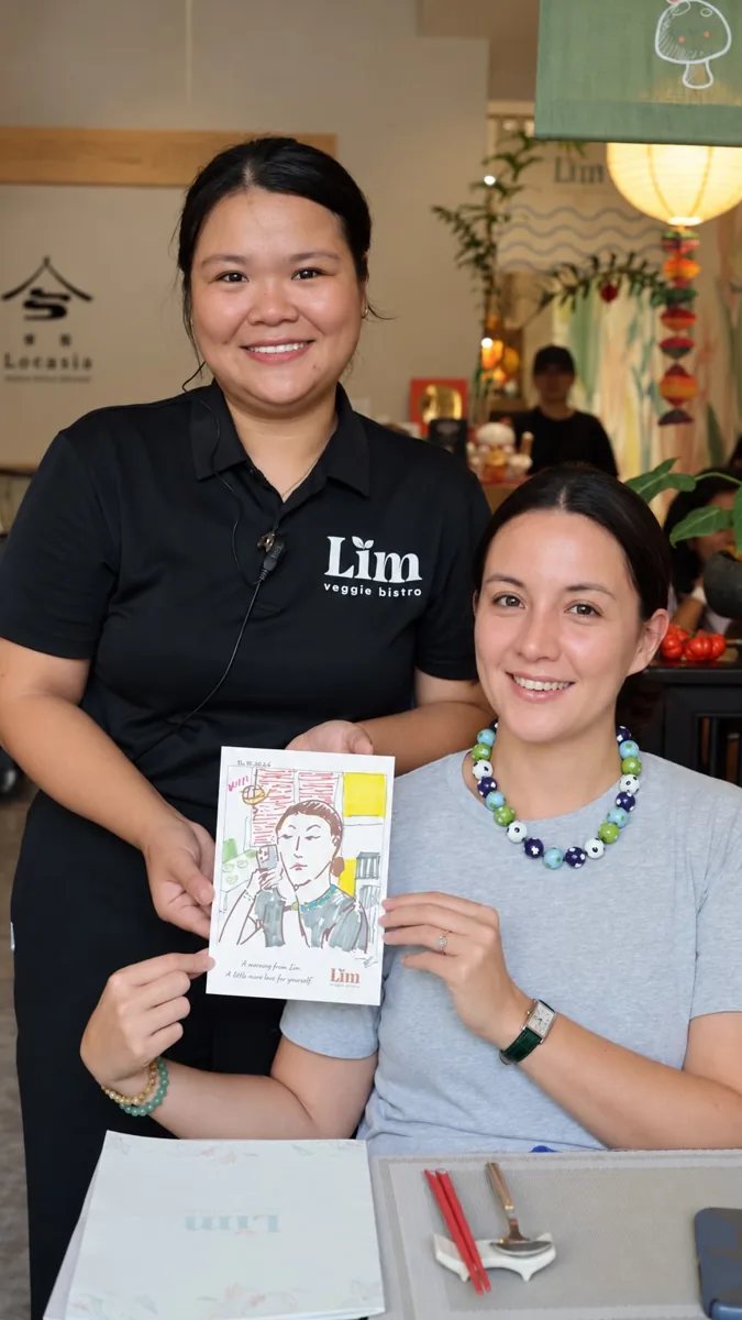 Lim Veggie Bistro staff and a guest holding a hand-drawn sketch portrait; the programme runs on 19 and 26 October.