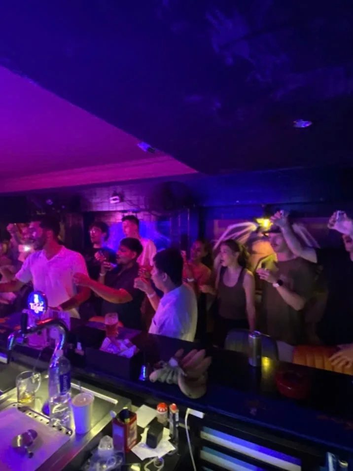 People at The Hideout Bar during the 24 October pub crawl; organizer schedule also appears in the caption.