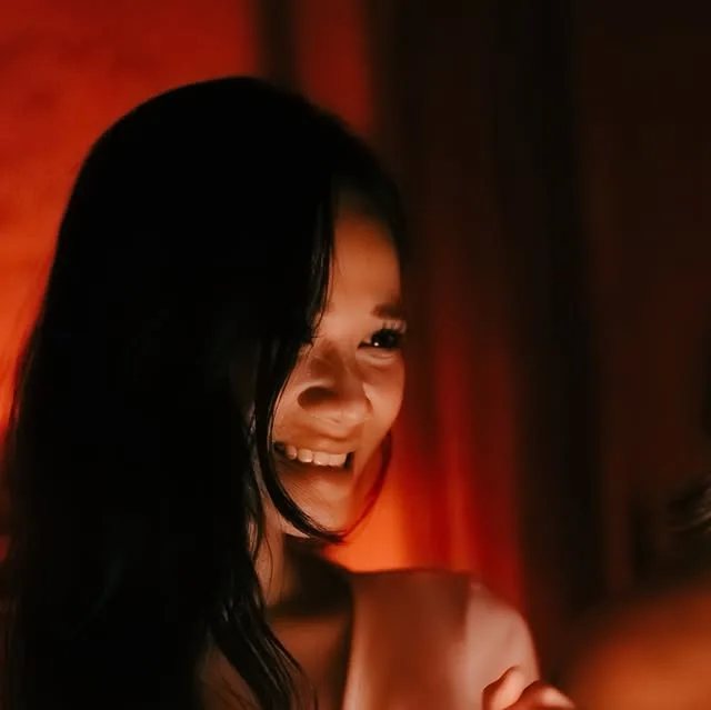 Smiling woman in warm red candlelight, cover image of the FEMME D'ARTH ladies' night Instagram post