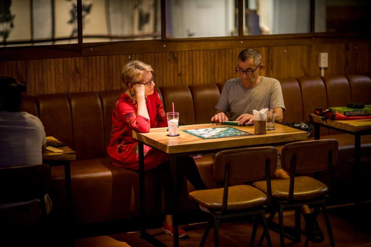 Guests playing Scrabble inside Malt South, 35 Nguyen Luong Bang